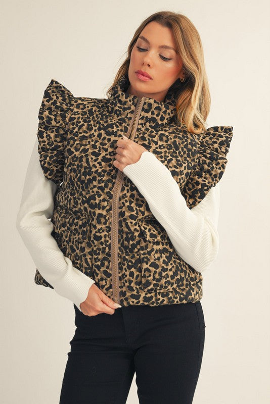 Woman wearing a leopard print vest over a white shirt on a plain background