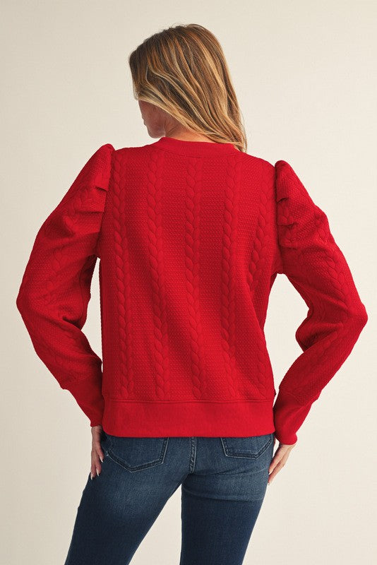 Person wearing a red sweater with a neutral background