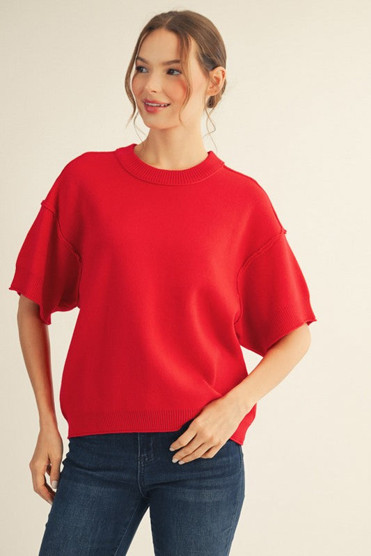Red drop shoulder sweater top with raw edge detail and relaxed fit.