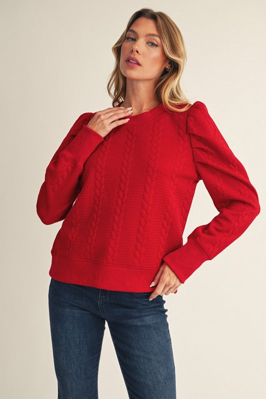 Woman wearing a red sweater and blue jeans on a beige background