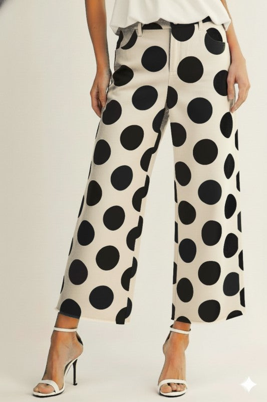 woman wearing cream wide leg trousers with large black polka dots styled with heels