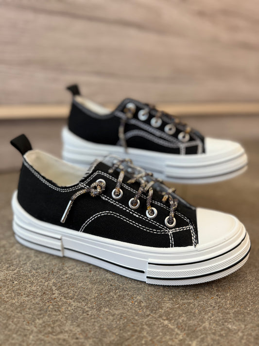 Black and white sneakers on a textured surface