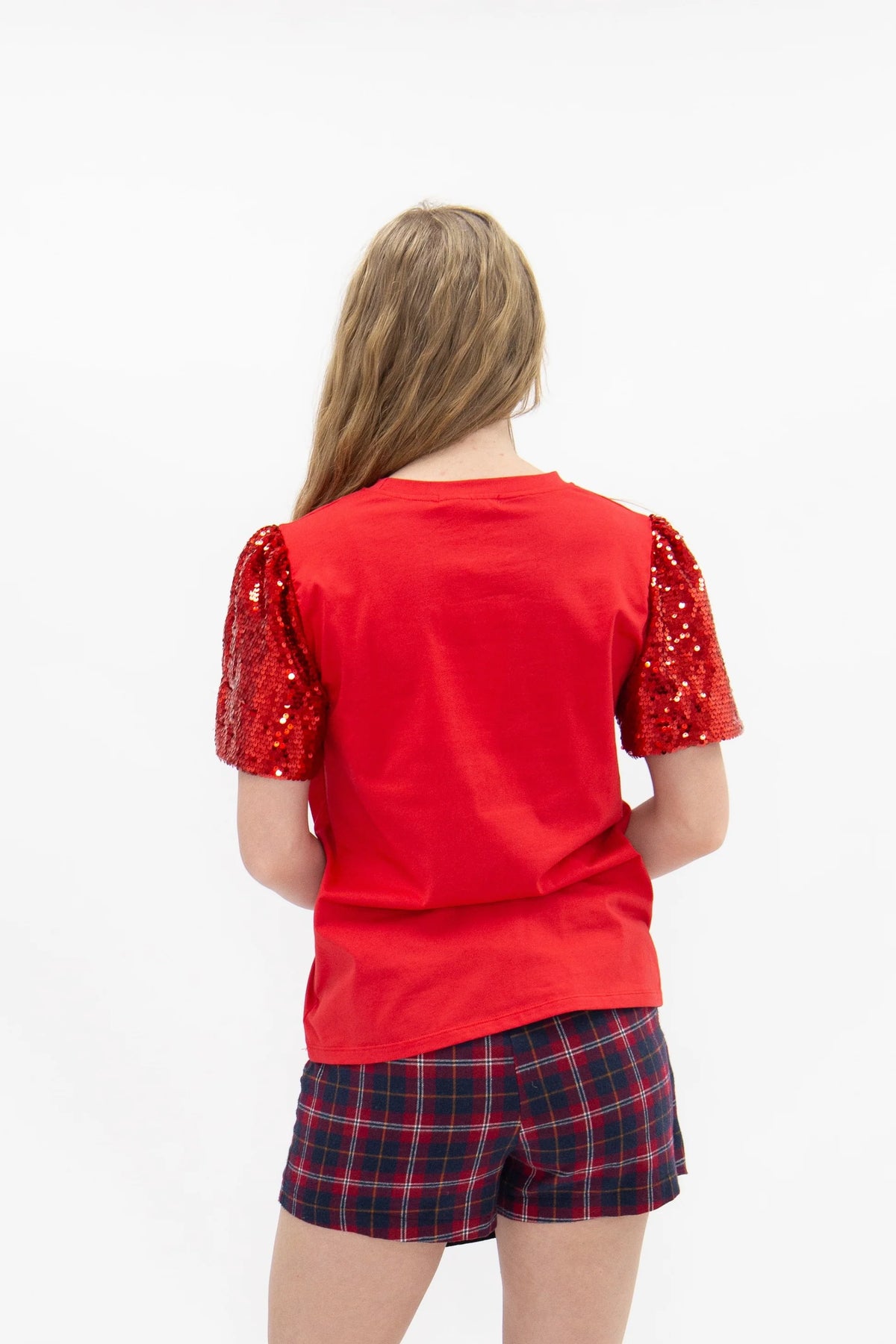 Back view of red Christmas tee with solid red body and sparkling short sequin puff sleeves.