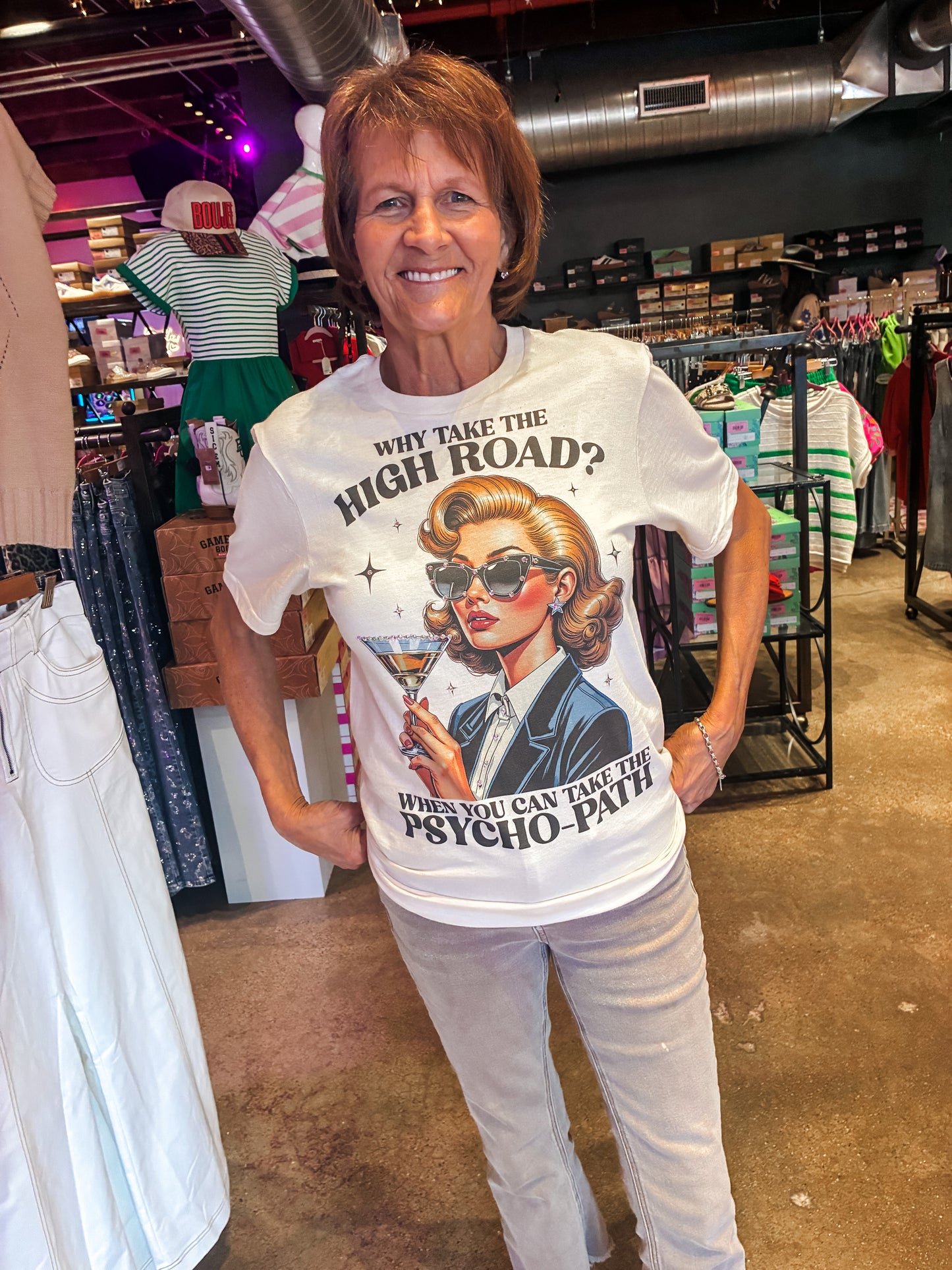 Women’s graphic tee featuring a vintage-inspired woman holding a martini and the phrase “Why Take the High Road When You Can Take the Psycho Path?”