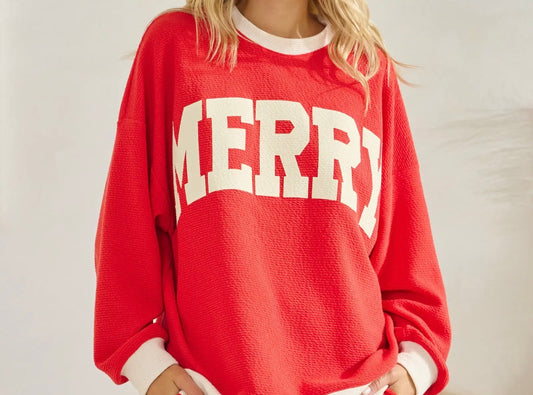 Women's red Merry Christmas pullover with oversized cream lettering and contrast trim.