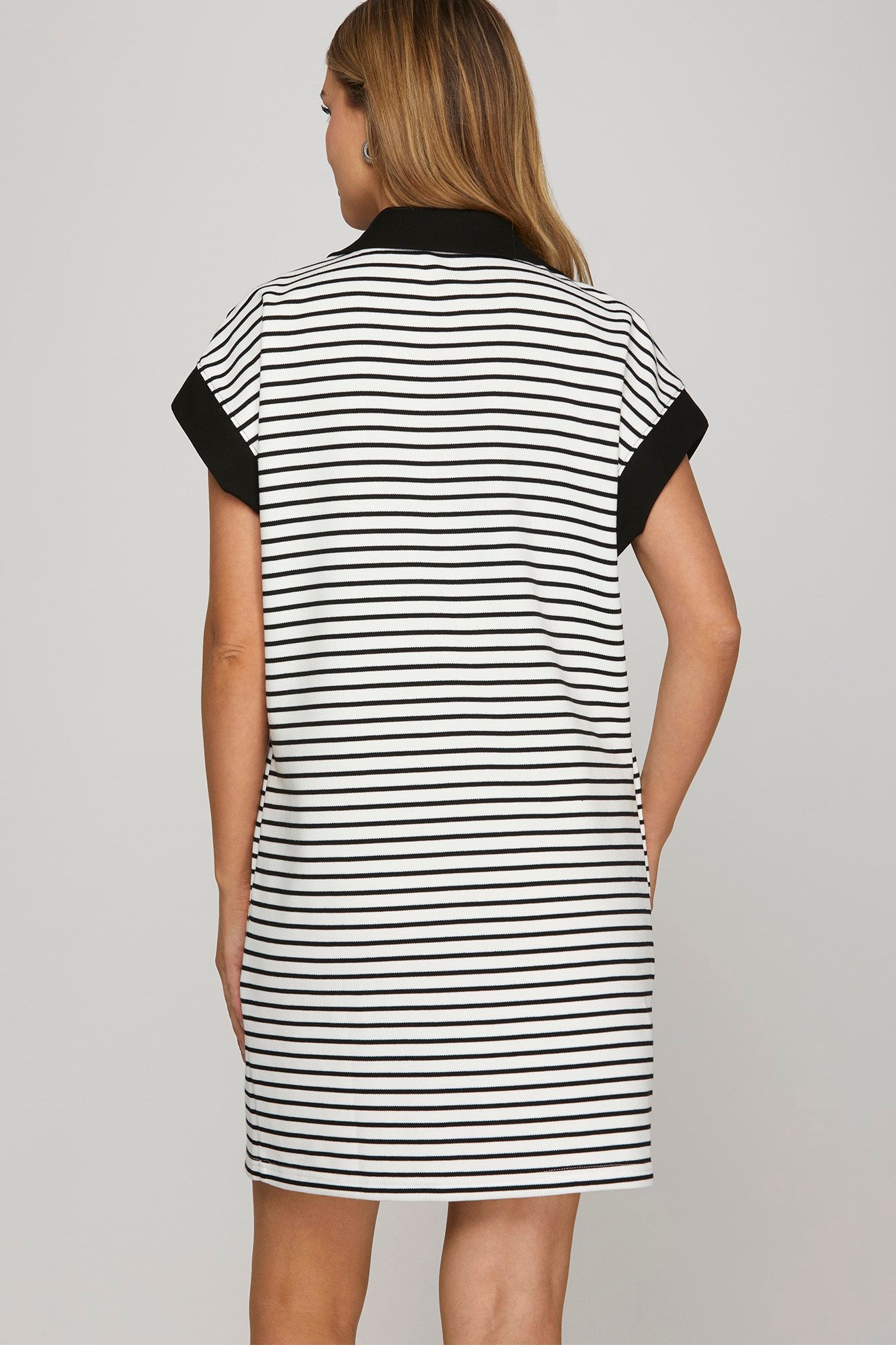 Back view of black half zip knit mini dress