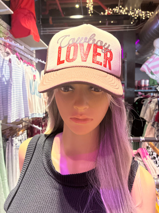 Cream and brown trucker hat featuring Cowboy Lover graphic with red lettering and mesh back design.