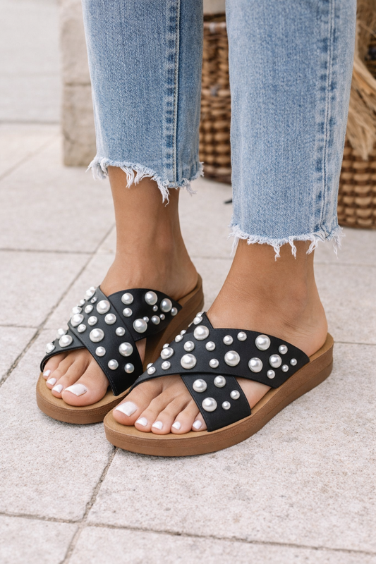 Women’s black pearl X-strap slide sandals with open toe design and cushioned flat sole.
