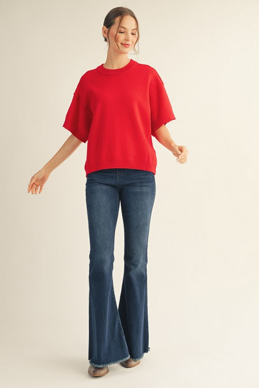Red drop shoulder sweater top with raw edge detail and relaxed fit.
