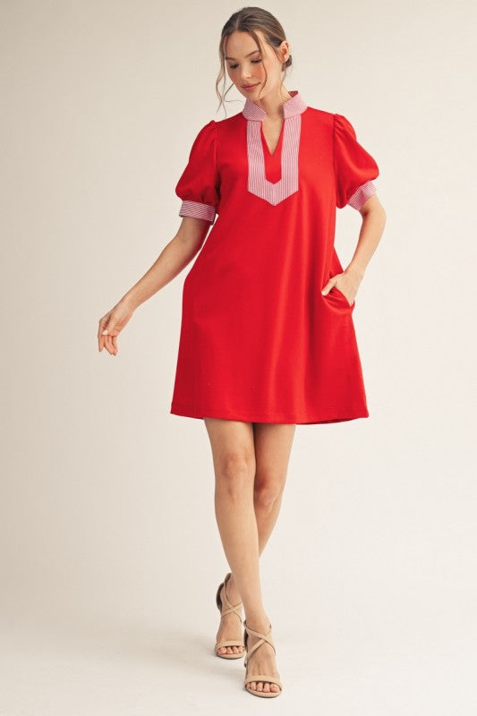 Red puff sleeve shift dress with stripe contrast detail, standing neckline, notched V-neck, and side pockets.
