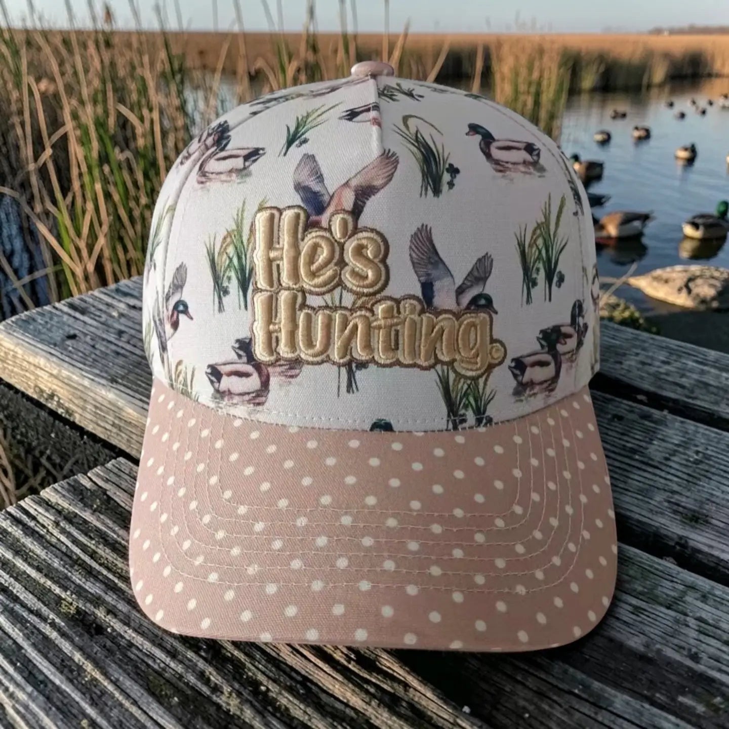 duck print trucker hat with embroidered “he’s hunting” text and polka dot brim
