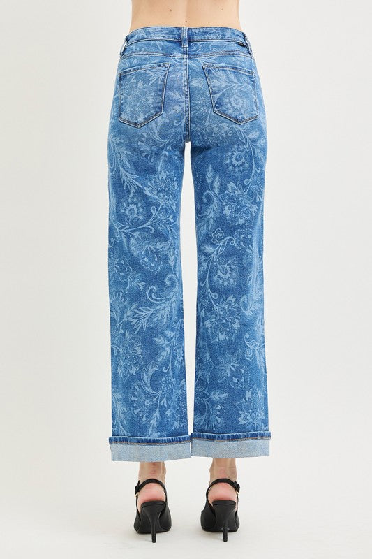 Blue patterned jeans worn by a person on a white background