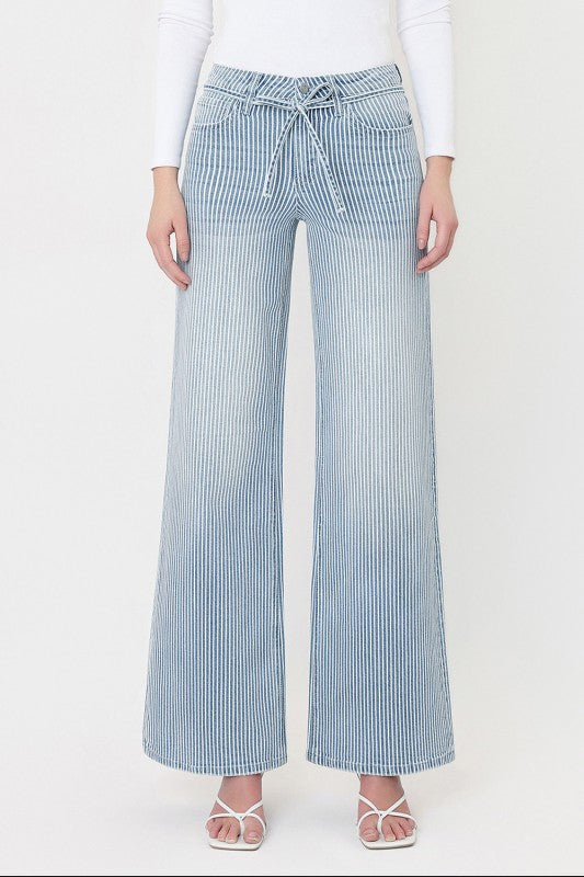 Model wearing blue striped high rise wide leg jeans with adjustable waist tie and comfort stretch denim.