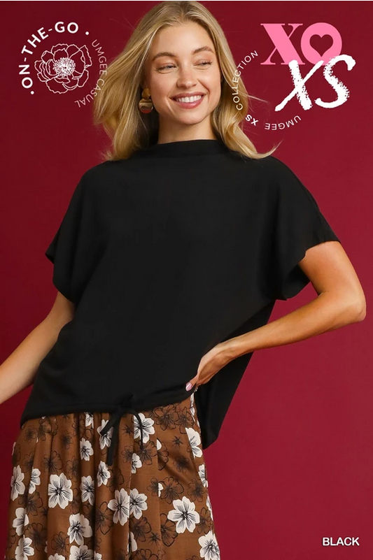 Woman wearing a black top with a red background featuring branding and text.