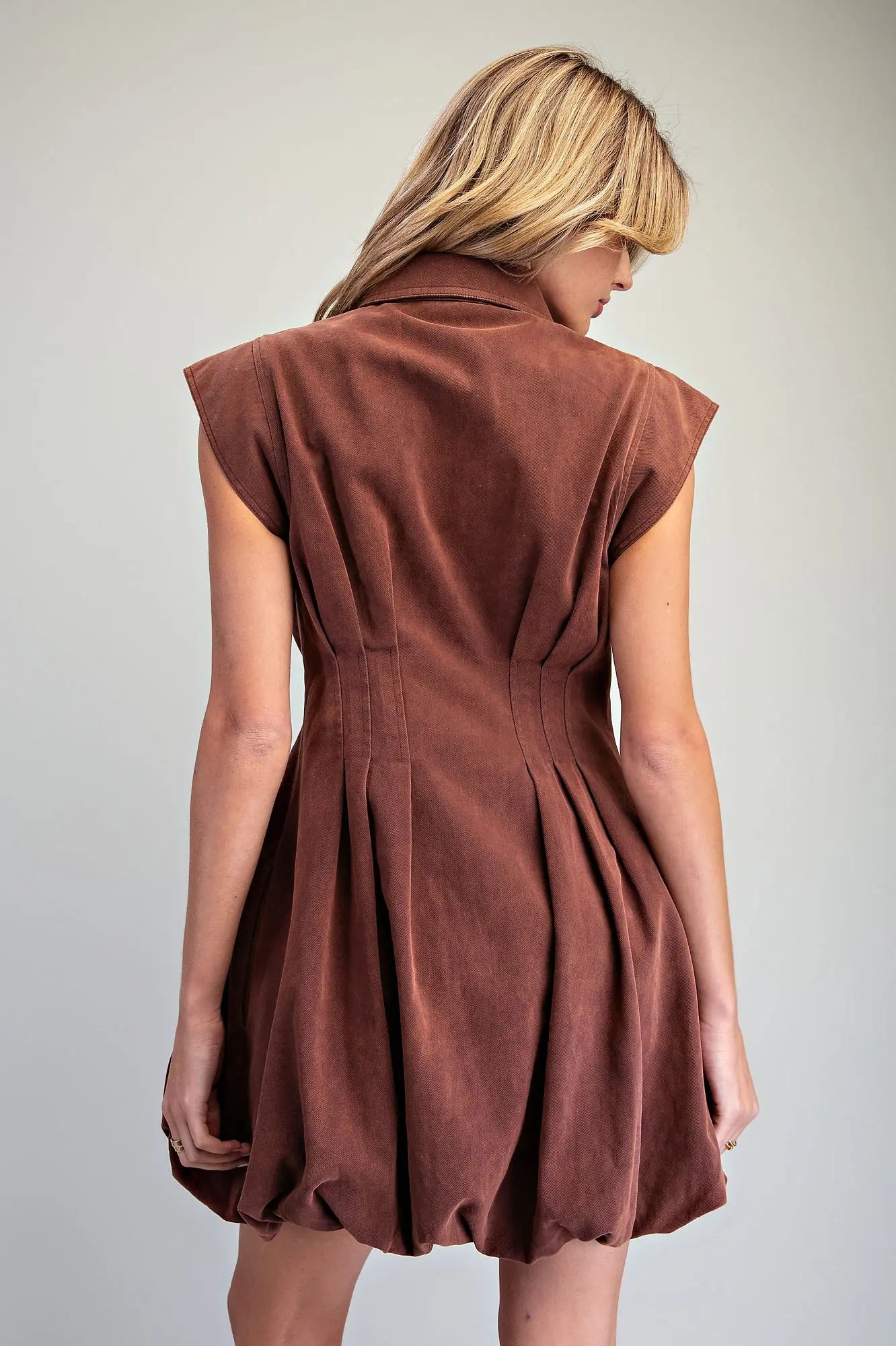 Back view of chocolate brown bubble hem mini dress with fitted pleated waist