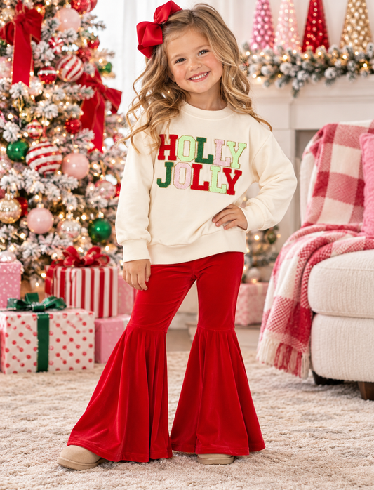 Girls' Christmas two-piece outfit featuring a cream Holly Jolly applique sweatshirt and bright red bell-bottom pants.