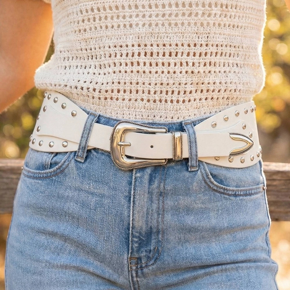 Ivory wide studded Western belt for women styled with light wash jeans and a cream crochet top