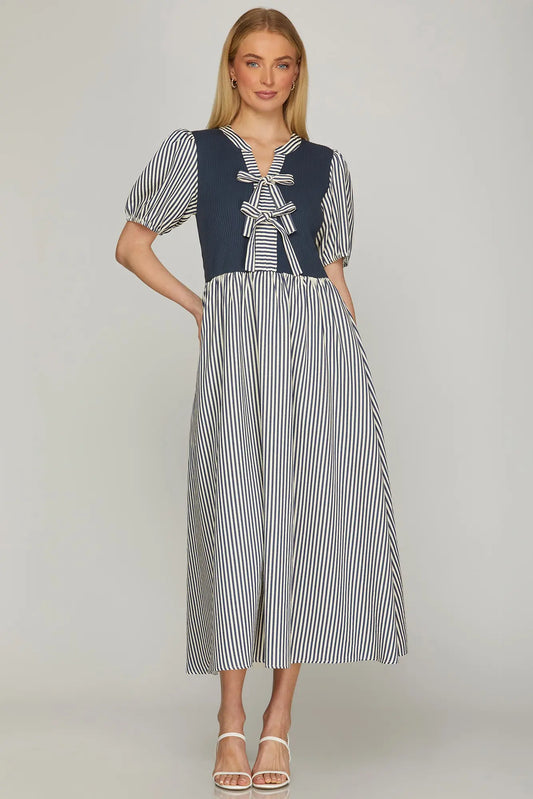 woman wearing navy and white striped midi dress with tie front detail and short puff sleeves
