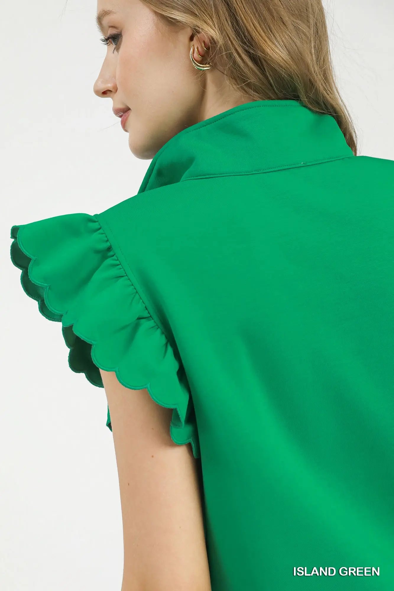 Ruffled sleeve detail on women’s green sweatshirt from Texas boutique