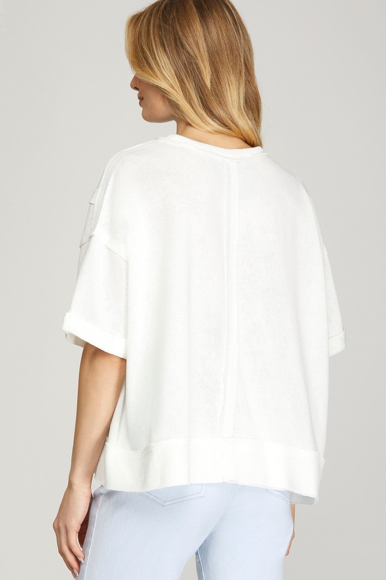 Back view of off white short sleeve knit top